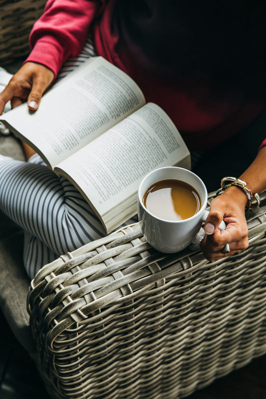 Person holding mug and reading book
