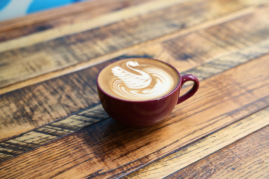 Cup with latte art on a wooden table