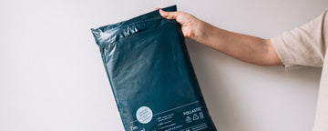 Person holding navy blue mailer bag