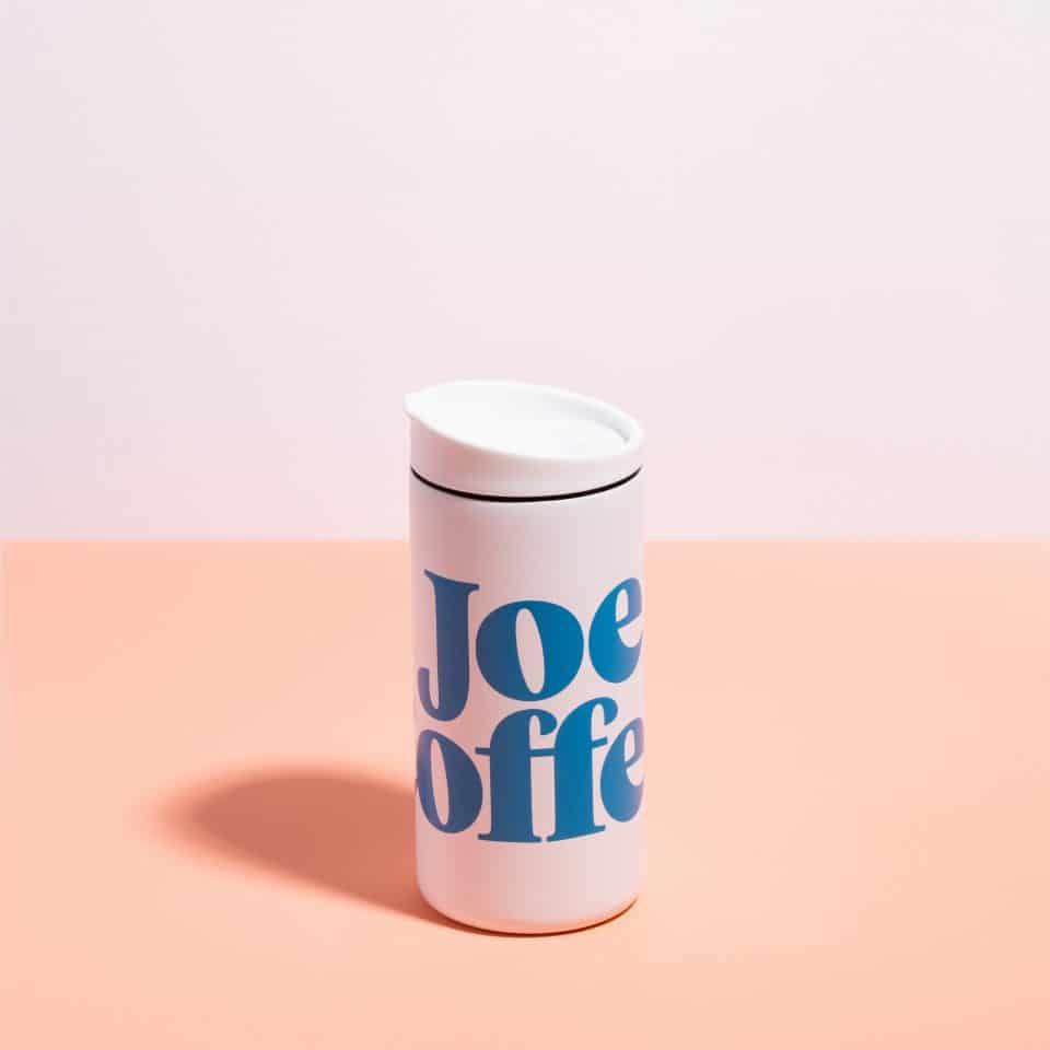 White travel mug with Joe Coffee on it