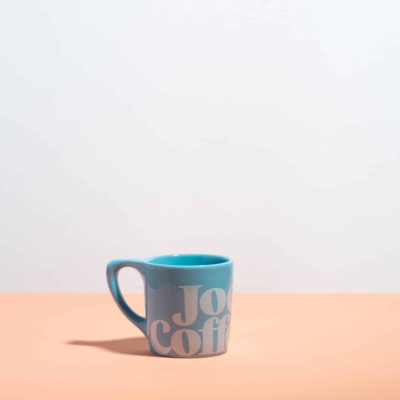blue mug with "joe coffee" on it