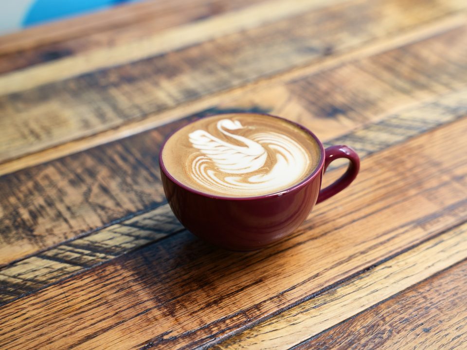 Cup with latte art on a wooden table