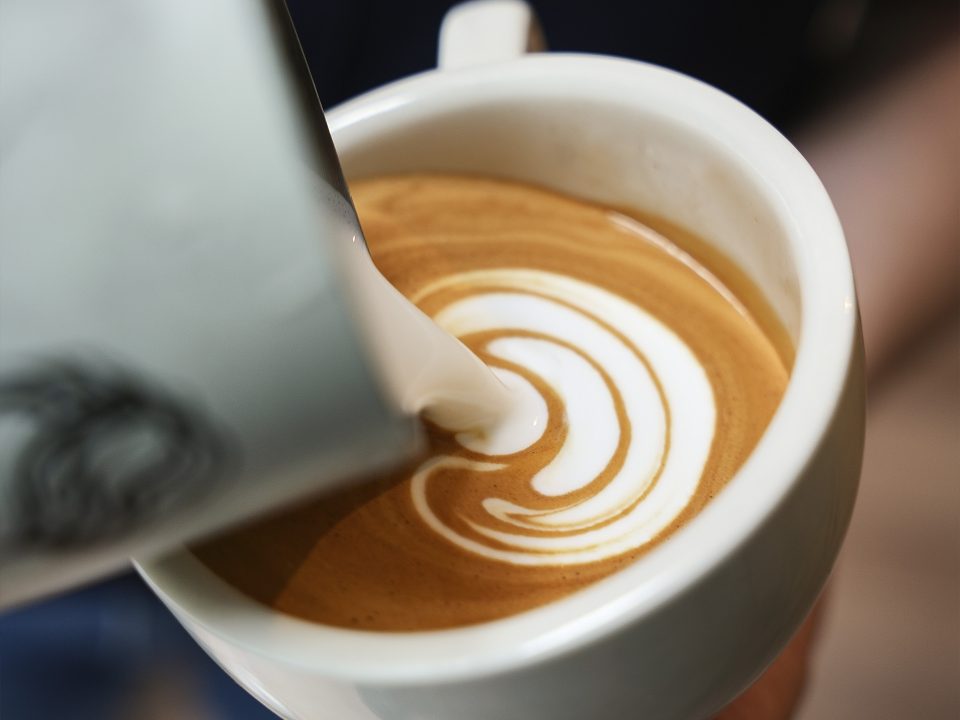 Pouring latte art into a mug
