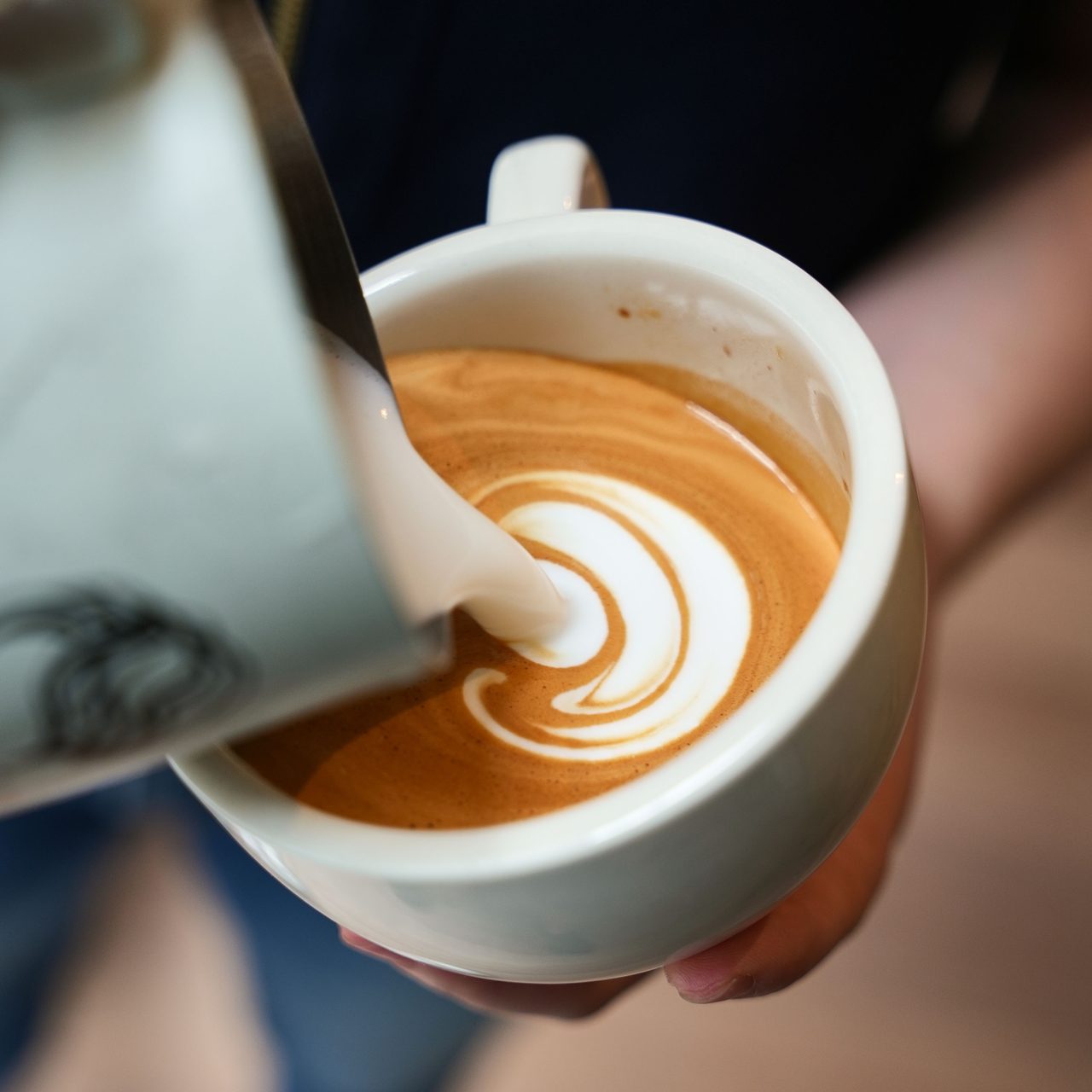Pouring latte art into a cup