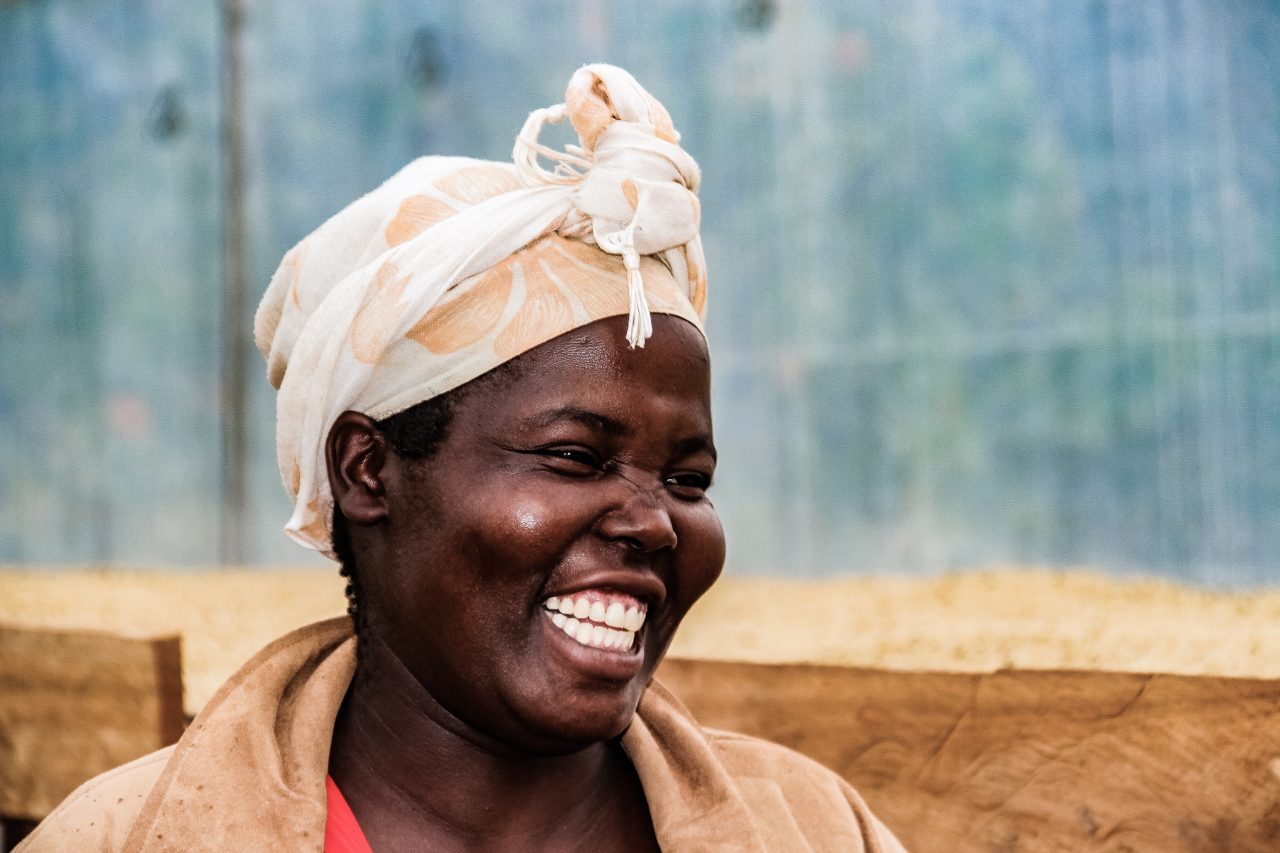 A woman producer from the Kapkiyai Womens Cooperative smiles and looks off camera